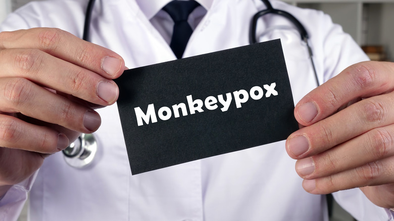 doctor holding paper saying "monkeypox"