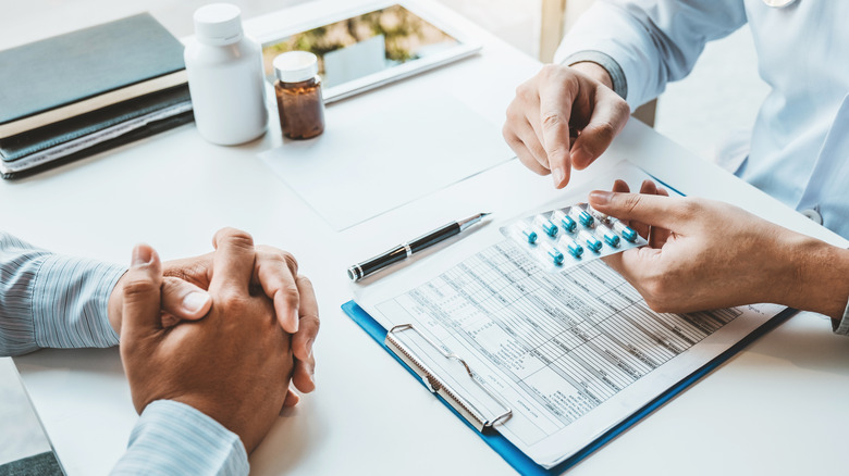 Doctor gives pills to patient