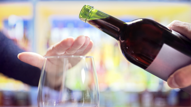 woman covering glass, refusing wine