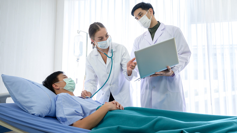 Two doctors examining a hospitalized patient 