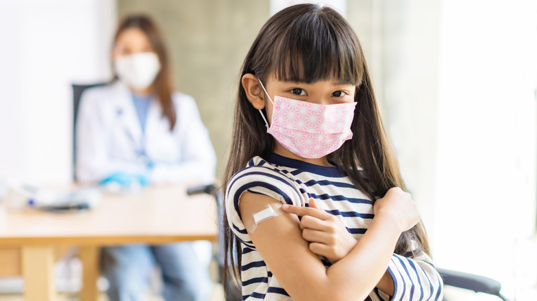 Girl pointing to bandaid on arm 