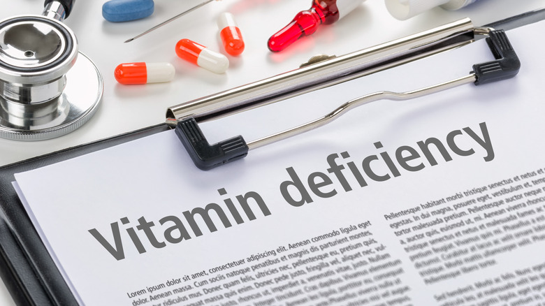 Clipboard paperwork reading "Vitamin Deficiency"