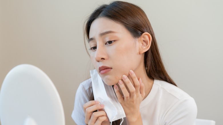 woman examining skin