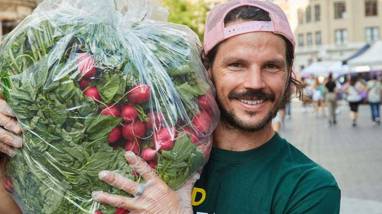 Dan Churchill smiling holding bag of radishes