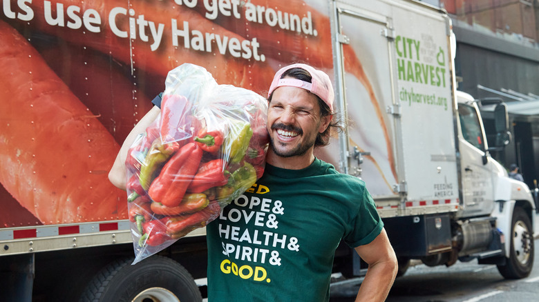 Dan Churchill smiling holding bag of peppers