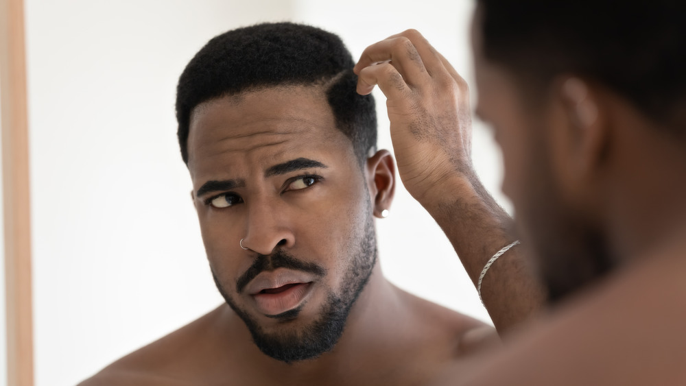 Young male checking for dandruff 