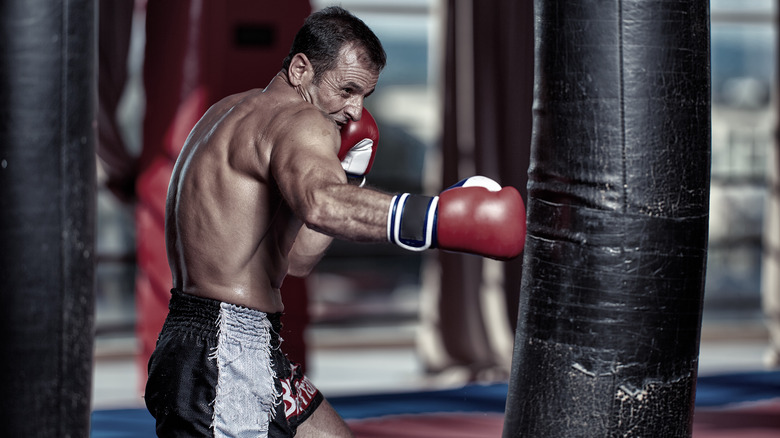 man hitting heavy bag