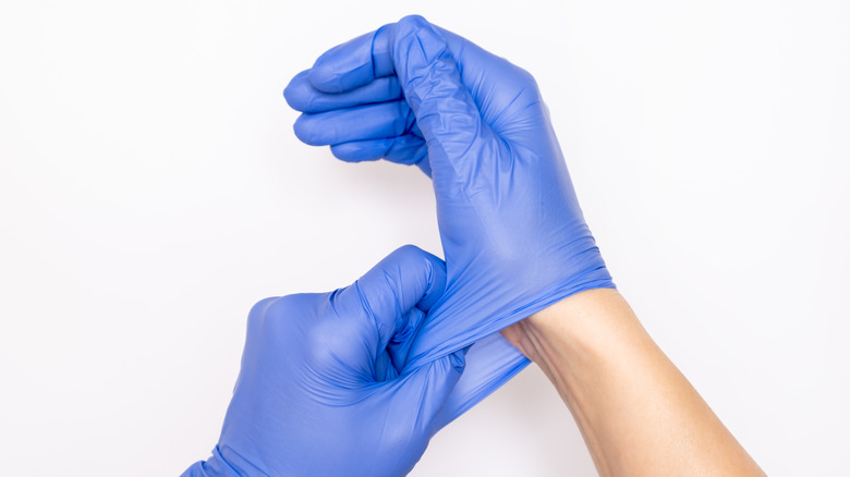nurse putting on blue gloves