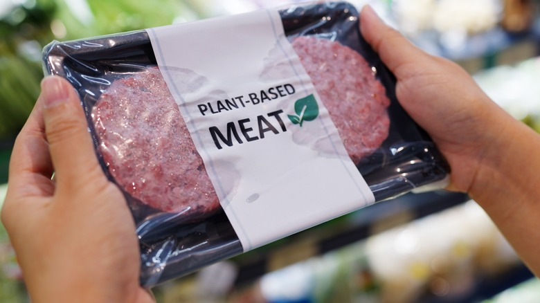 woman holding plant-based meat burger product