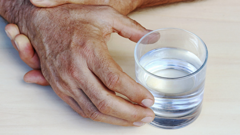 elderly hands with water glass