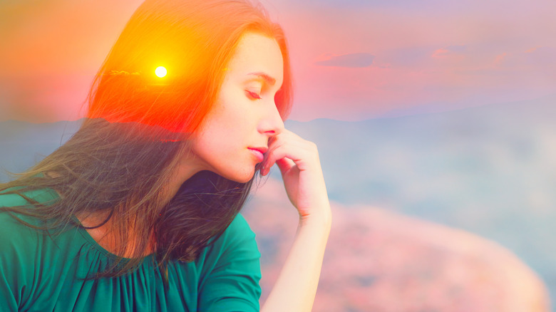 translucent image of woman against sunset