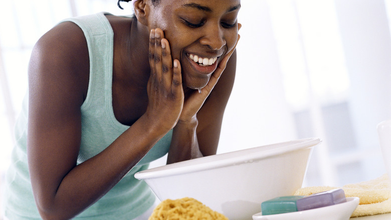Smiling woman washing face