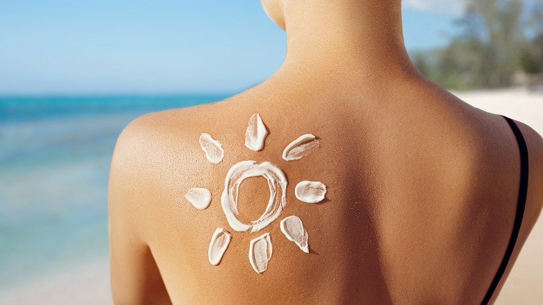 Sun draw with cream on woman's back