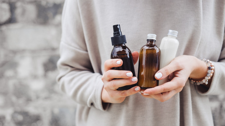 Manicured hands holding skin care products