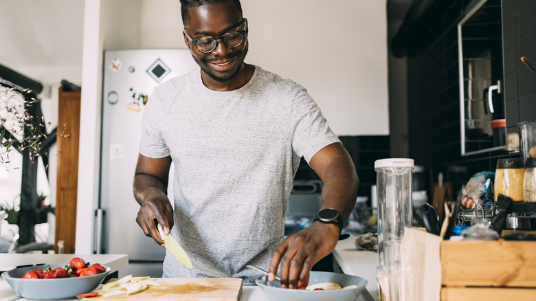 healthy man cutting fruit