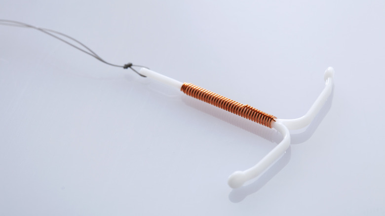 A copper IUD on a white background