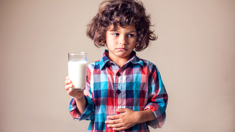 Sad child holding milk