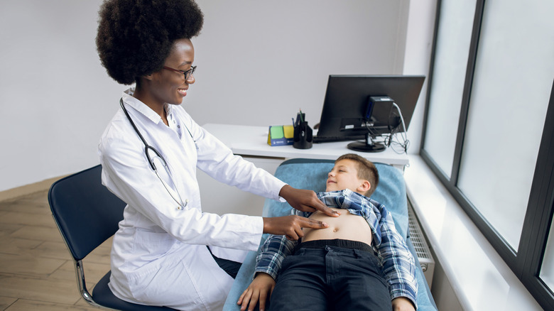 Doctor examining boy's stomach
