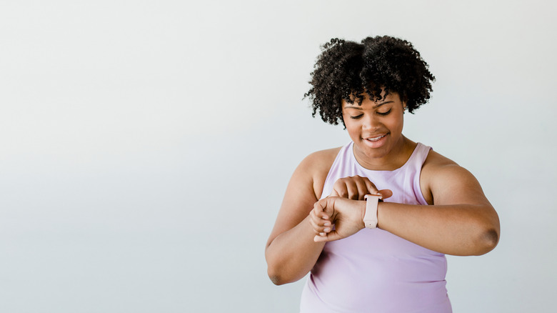 Woman in workout clothes looking at her smartwatch