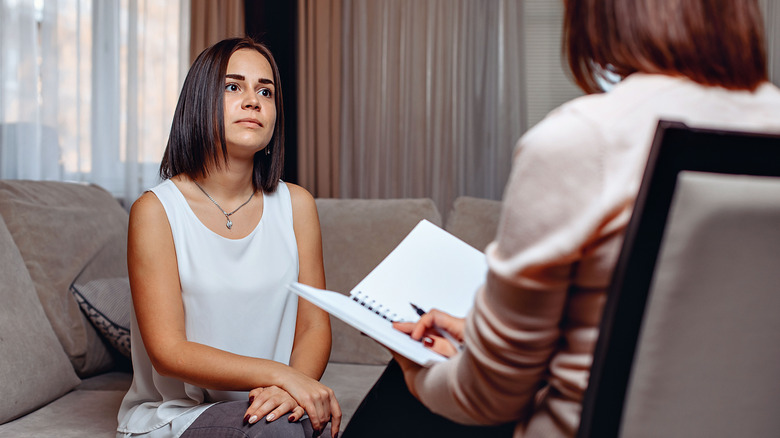 woman in a therapist's office looking unhappy