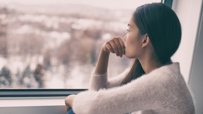 woman staring out the window of a train