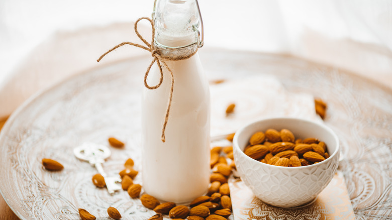 bottle of almond milk surrounded by almonds