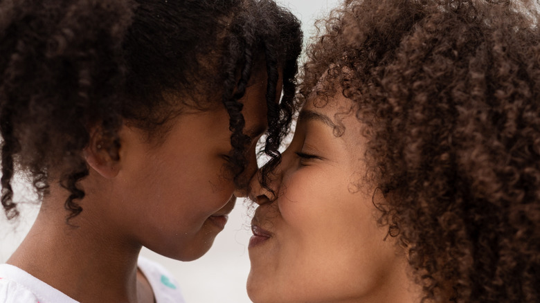 adult and child rubbing noses