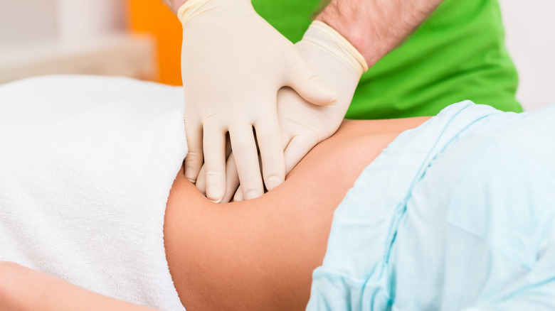 woman getting abdominal massage during colonic 