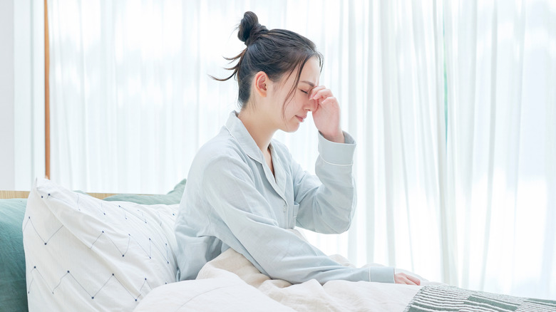 Young woman waking up groggy