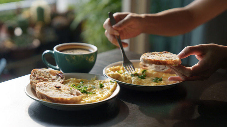 woman eating eggs and toasted bread