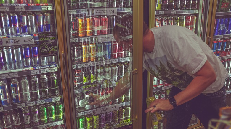 Man buying energy drinks at store 