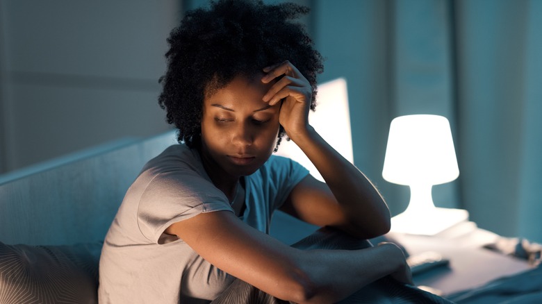 Tired woman sitting up in bed