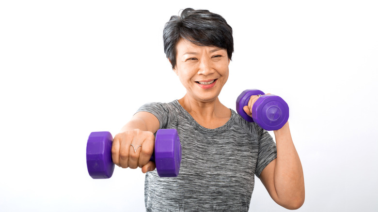 older woman exercises with weights 