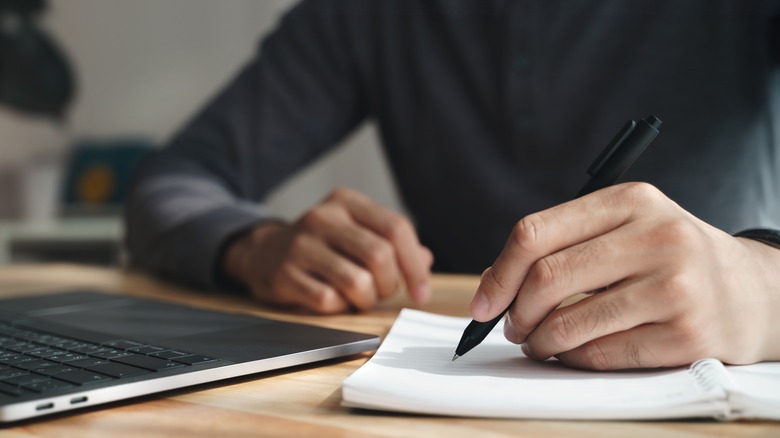 man writing with left hand