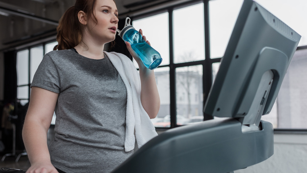 woman drinking on treadmill