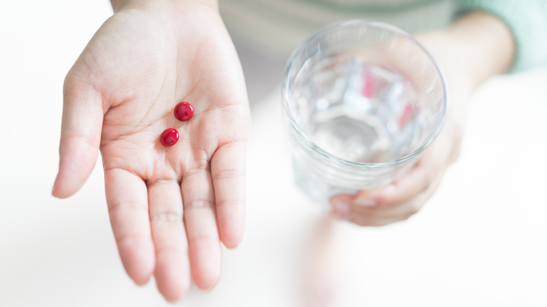 Woman with red pills in her hand