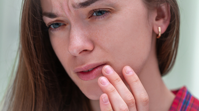 Woman touching her lip with worry