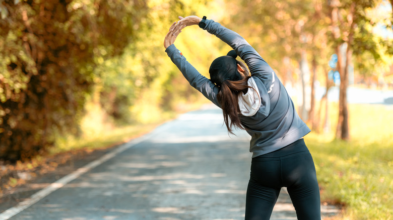 A woman stretches before a run