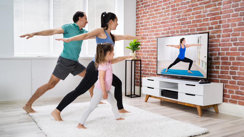 Family doing yoga with TV