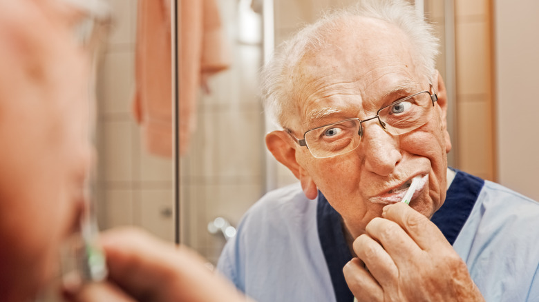 older man brushing teeth