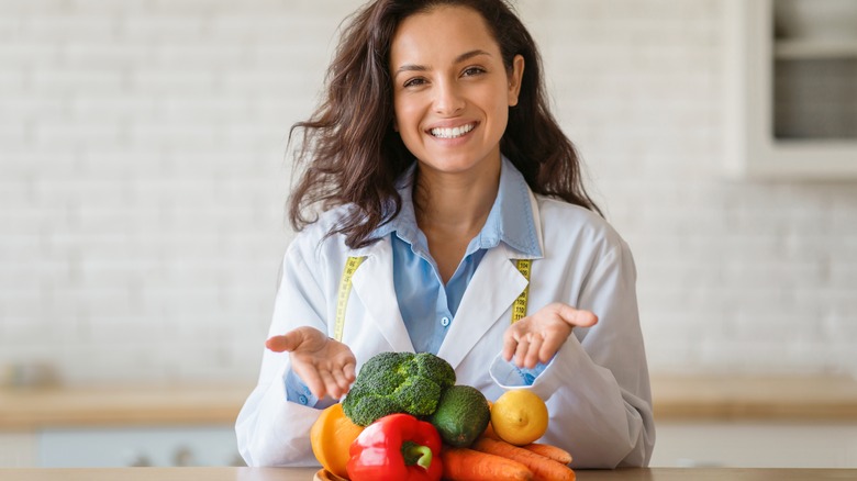 dietician shows fruits and vegetables on the table