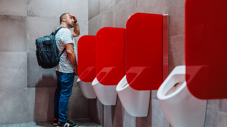 man at a public urinal