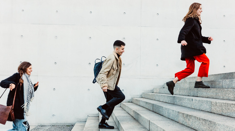 three people taking a set of stone stairs