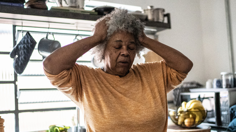 senior woman feeling dizzy in her kitchen
