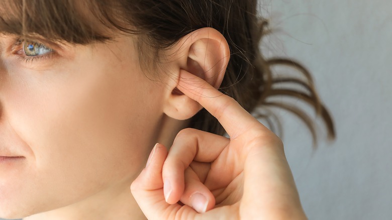 Woman sticking finger in ear