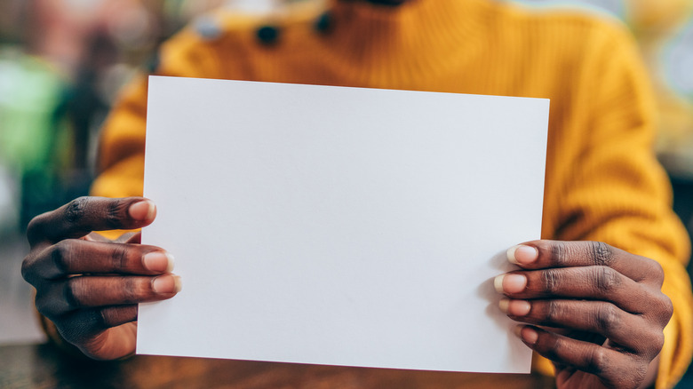 Woman holding sheet of paper