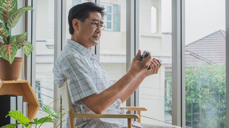 Man seated using handgrip devices