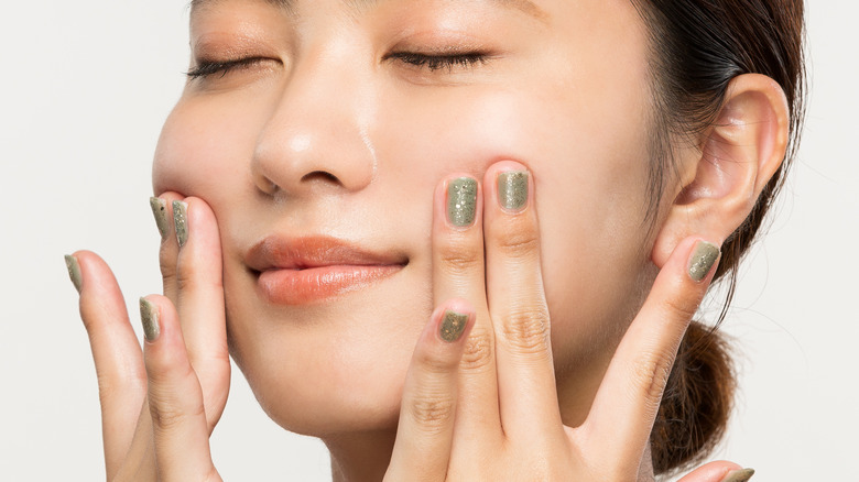 Woman pulling back on face skin