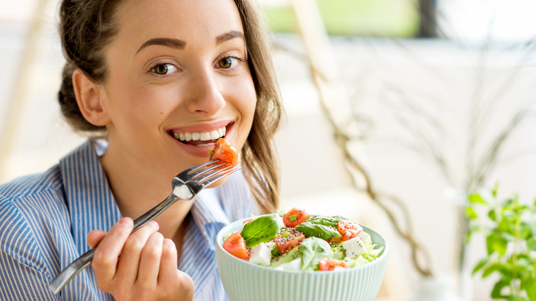 Woman eating a salad with tomatoes