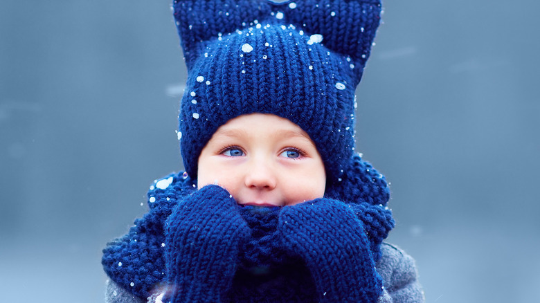 child wearing hat and scarf on snowy day